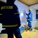 Im Obergeschoss wird ein Wanddurchbruch hergestellt. Zuerst wiederholt Bastian Bense ruhig und methodisch mit einer Bleistiftskizze auf der weißen Tapete die Theorie. (Foto: THW/Sandro Wiggerich)