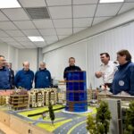 Im Planspiel am Stadtmodell diskutieren THW-Kräfte und der stellvertretende Leiter des Amtes für Feuerschutz und Rettungswesen der Kreisstadt Unna Christian Luppa (2. v.r.) konkrete Fragestellungen der praktischen Arbeit im Einsatz. (Foto: THW/Sandro Wiggerich)